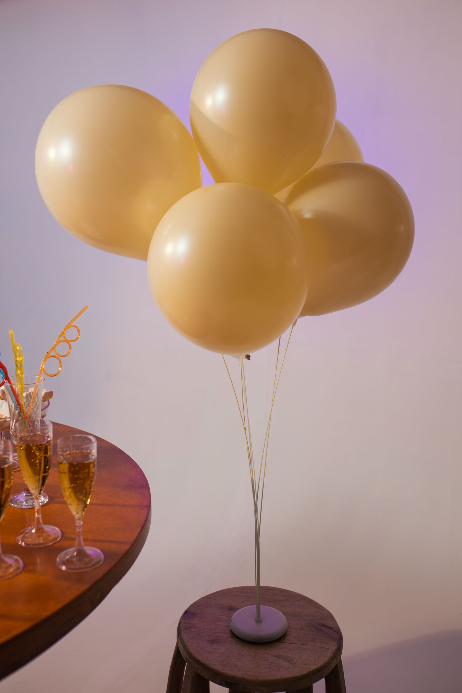 A birthday setting ready for guests, with golden balloons and champagne glasses.